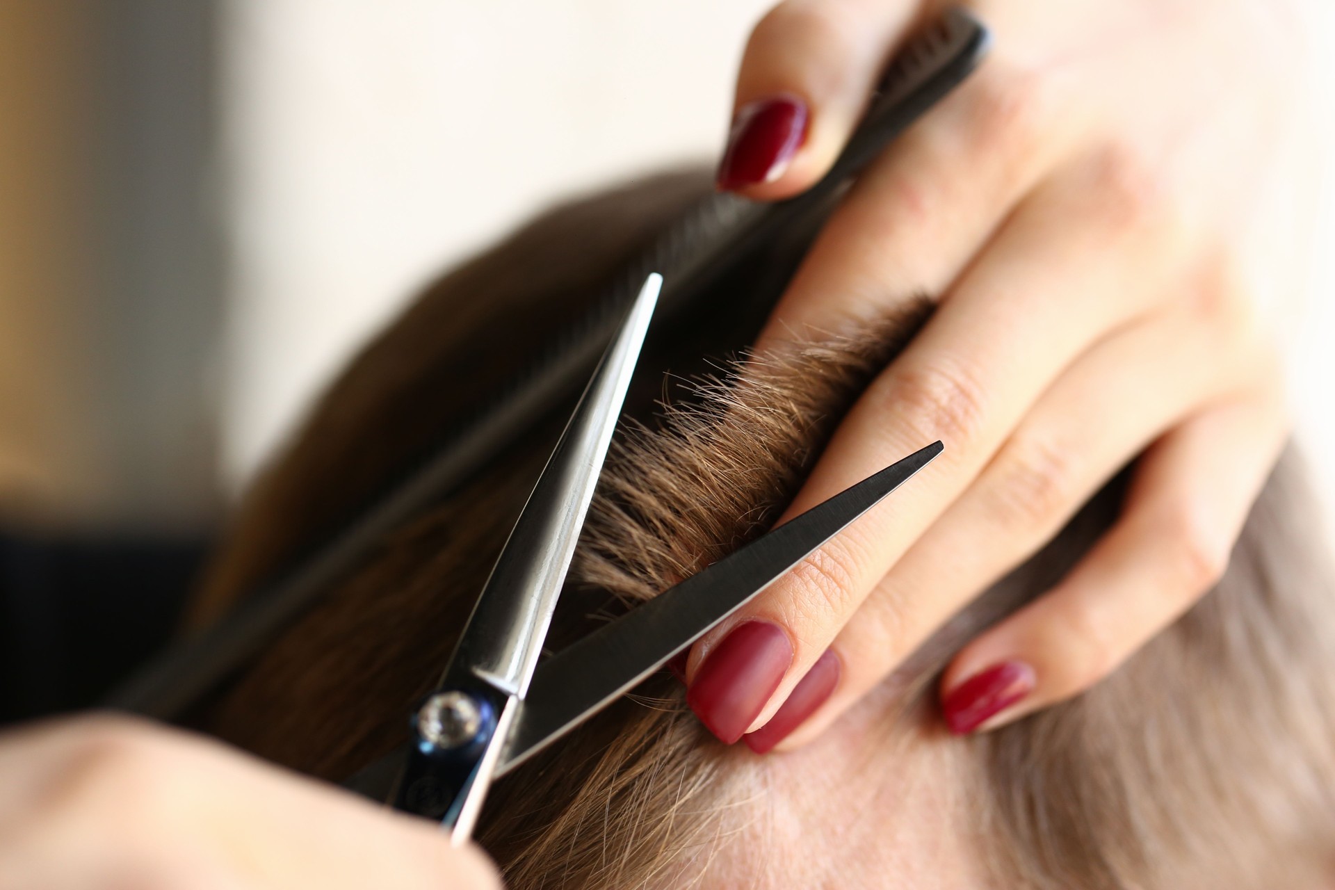 Donna mano tenere i capelli forbici parrucchiere